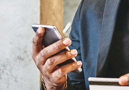 Close up of a man holding his smartphone and his debit card