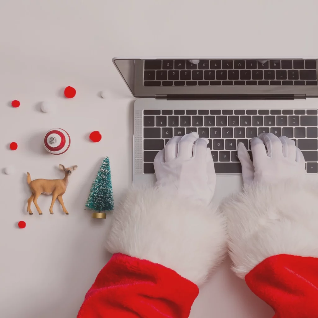 Close up of Santa Claus typing on a laptop