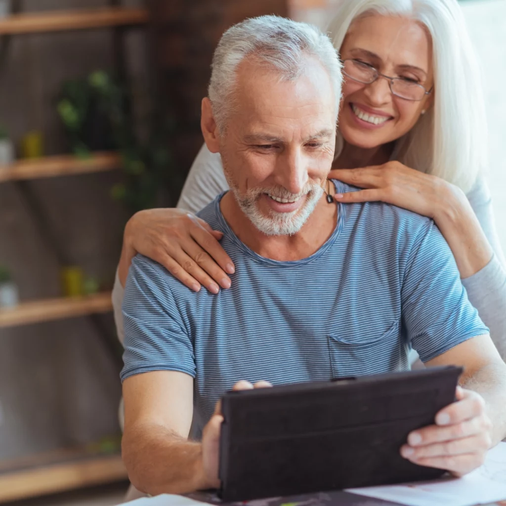 couple with gray hair looking at laptop