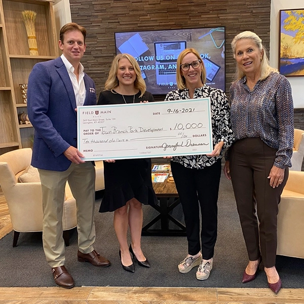 Field and Main Employees holding a large check