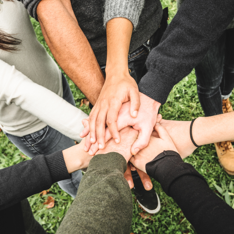Group of volunteer hands in the middle working together