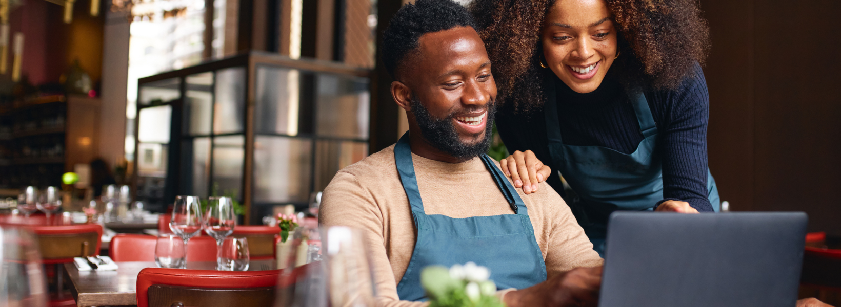 Small business owners using laptop in restaurant